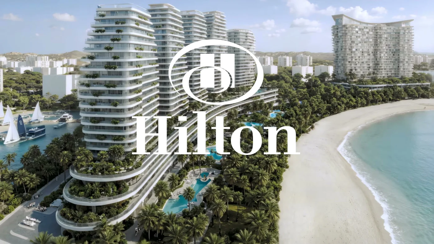 Визуализация: Логотип Hilton поверх визуализации Five Stones у пляжа — кадр официального ролика